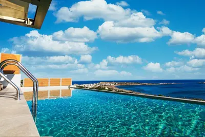 a swimming pool with a view of the ocean at Amphitheatre Suites in Palaiochóra