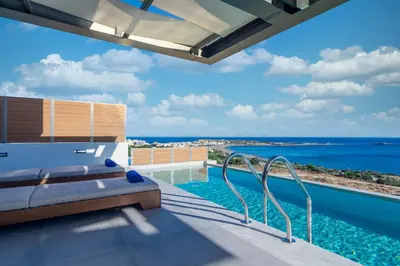 a view of the ocean from the balcony of a house at Amphitheatre Suites in Palaiochóra