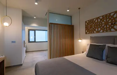 a bedroom with a large bed and a sliding glass door at Amphitheatre Suites in Palaiochóra