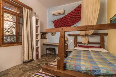 a bedroom with a wooden bunk bed and a window at Spitia Anoi in Palaiochóra