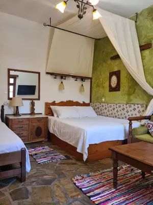 a bedroom with two beds and a table at Spitia Anoi in Palaiochóra