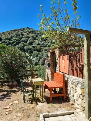 a bench and a table and a chair in a yard at Spitia Anoi in Palaiochóra