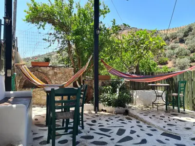 a patio with hammocks and a table and chairs at Spitia Katoi in Palaiochóra