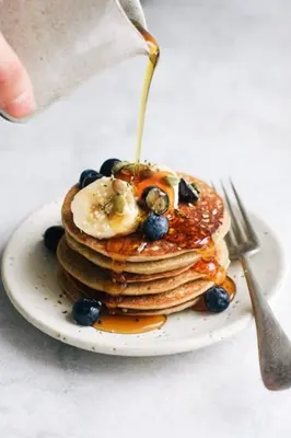 a plate with a stack of pancakes with syrup and blueberries at Casa Bene in Chania Town