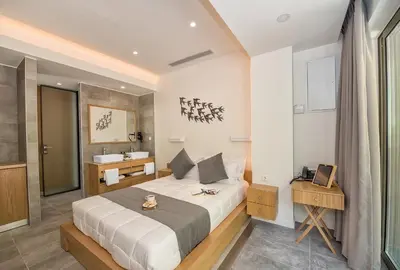 a bedroom with a large bed and a sink at Lilium Luxury Suites in Agia Marina Nea Kydonias