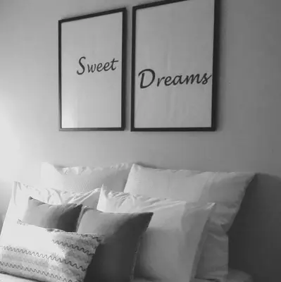 three pictures on the wall above a bed with white pillows at New Sea Escape Boutique Apt-Agii Aposto li beach in Chania Town