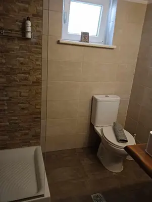 a bathroom with a toilet and a window and a tub at Chania Nice Apartment in Chania Town