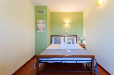 a bedroom with a large bed with green walls at Kaktos 1 in Kissamos