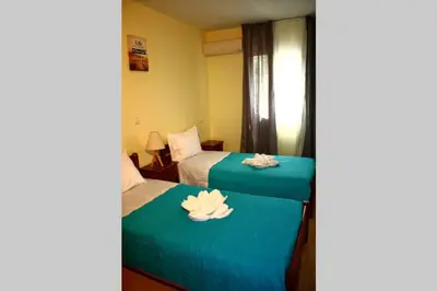 two beds in a hotel room with towels on them at Kaktos 1 in Kissamos