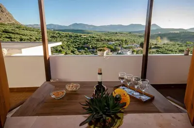 a table with a bottle of wine and glasses on it at Trouli Rokka House in Kissamos