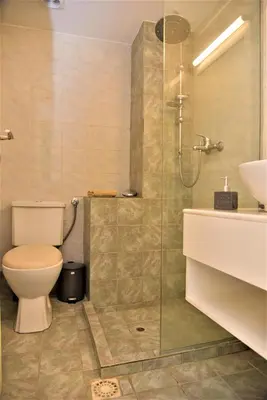 a bathroom with a toilet and a shower and a sink at Emerald Apartment Halepa in Chania Town