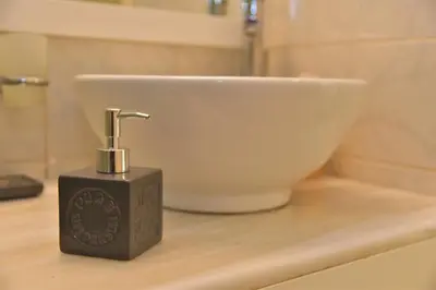 a soap dispenser sitting on a counter next to a sink at Emerald Apartment Halepa in Chania Town