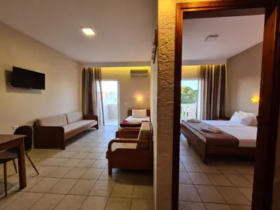 a hotel room with a bed and a living room at Abella Hotel in Agia Marina Nea Kydonias
