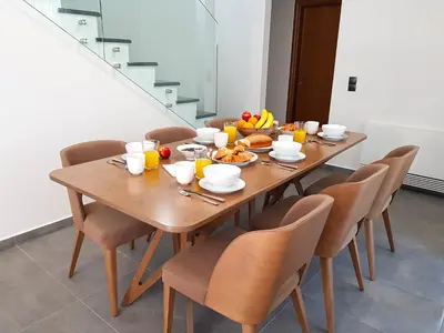 a wooden table with breakfast foods on it with chairs at Four Seasons Homes in Stalos