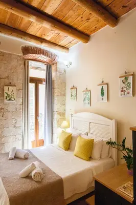 a bedroom with a large white bed with yellow pillows at Charming Studio in the Old Town in Chania Town