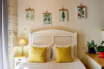 a bedroom with a white bed with yellow pillows at Charming Studio in the Old Town in Chania Town