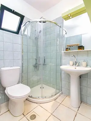 a bathroom with a shower and a toilet and a sink at Venizelos Studios in Plataniás