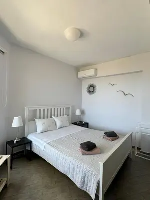a bedroom with a large bed with two night stands at Venizelos Studios in Plataniás