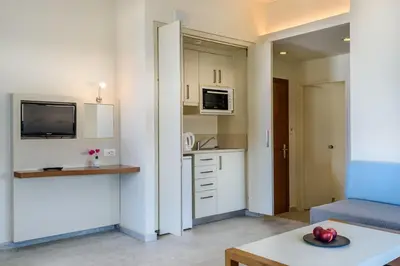 a kitchen and a living room with a couch and a table at Despina Apartments in Plataniás