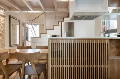 a kitchen and dining room with a wooden table and chairs at Chania Escapes City Loft 50 meters by the Sea in Chania Town
