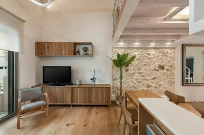 a living room with a television and a table at Chania Escapes City Loft 50 meters by the Sea in Chania Town