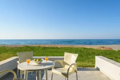 a patio with a table and chairs and the ocean at Kostakis Beach in Gerani Chanion