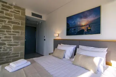 a bedroom with a bed with white sheets and pillows at Athinais villa in Palaiochóra