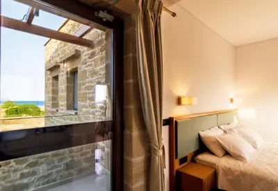 a bedroom with a view of a bed and a window at Anma Villa in Palaiochóra