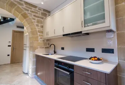 a kitchen with wooden cabinets and a bowl of fruit on the counter at Anma Villa in Palaiochóra