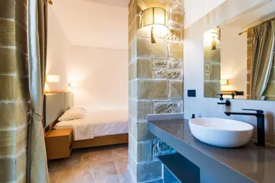 a bathroom with a sink and a bed in a room at Anma Villa in Palaiochóra