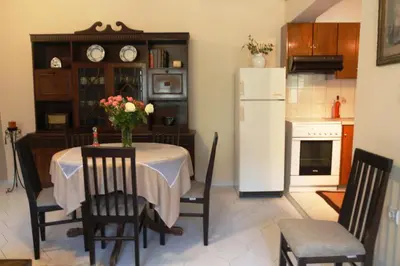 a kitchen with a table and a white refrigerator at Kleanthi's House in Chania Town