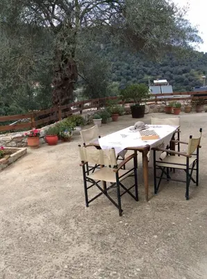 a table and chairs in a patio with plants at Kleanthi's House in Chania Town