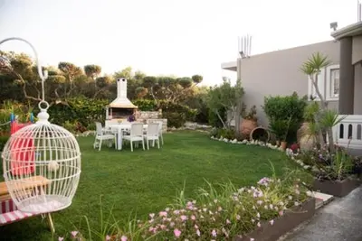 a garden with a table and chairs and a bird cage at Villa sotiris in Kissamos