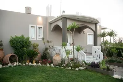 a house with a gate and a porch with plants at Villa sotiris in Kissamos