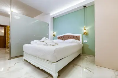 a bedroom with a white bed with a glass wall at Konmari Boutique Suites in Chania Town