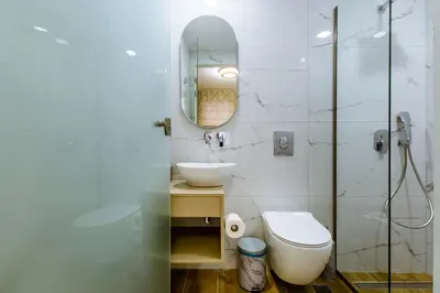 a bathroom with a toilet and a sink and a mirror at Konmari Boutique Suites in Chania Town