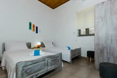 a white bedroom with a bed and a desk and a bed at M & E Kissamos sea view house in Kissamos