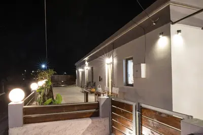 a patio at night with lights on the side of a house at M & E Kissamos sea view house in Kissamos