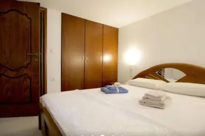a bedroom with two beds with white sheets and a wooden cabinet at Apartment with Premium Facilities in Chania Town