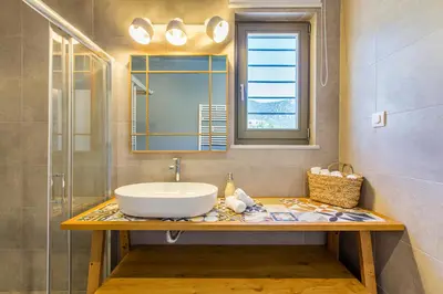 a bathroom with a sink and a mirror at Villa Skyphos in Ammoudari