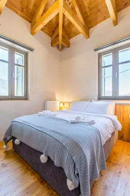 a large bed in a bedroom with wooden ceilings at Villa Skyphos in Ammoudari