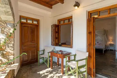 a room with a table and chairs and a mirror at VENTUS Studios in Khóra Sfakíon