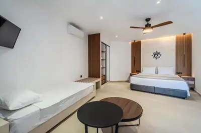a bedroom with two beds and a table at VENTUS Studios in Khóra Sfakíon