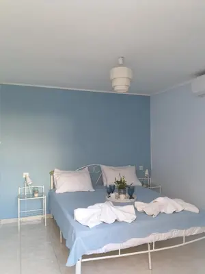 a blue bedroom with a bed with a blue wall at Nikoleta Apartment in Chania Town