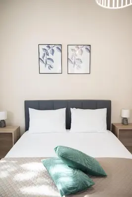 a bedroom with a white bed with three pictures on the wall at Calme luxury residence in Chania Town