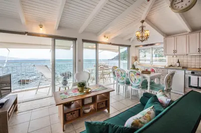 a kitchen and living room with a view of the ocean at Dream House Efi in Ravdhoúkha