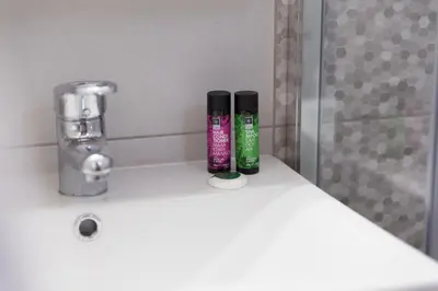 two bottles ofodorizers sitting on top of a bathroom sink at Irene Suite Chania in Kato Daratso