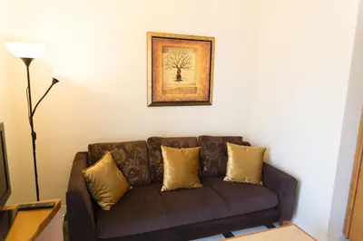a brown couch in a living room with a picture on the wall at Nicky Apartments Chania in Chania Town
