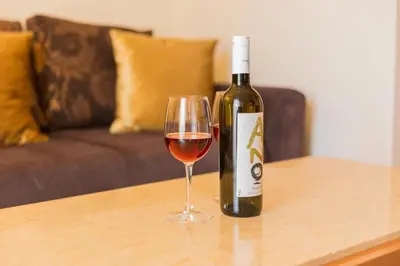 a bottle of wine and a glass on a table at Nicky Apartments Chania in Chania Town