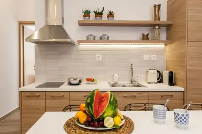 a kitchen with a bowl of fruit on a table at Blue Jasmine Apartments in Chania Town